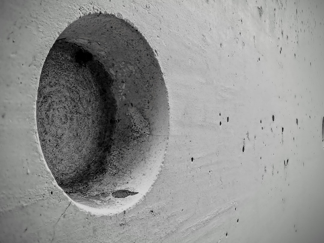 An abstract detail of cast concrete within the Tulach a’ tSolais 1798 memorial in County Wexford, Ireland. The circular recess and weathered surface emphasise material texture, shadow, and form, reflecting the monument’s minimalist architectural language and its quiet commemorative purpose.