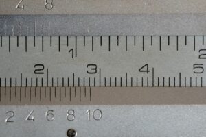 Close up of a vernier caliper ruler with visible markers for 1 in, 2 cm, 3 cm, 4 cm, and 5 cm