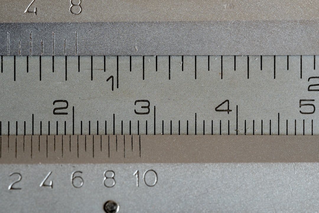 Close up of a vernier caliper ruler with visible markers for 1 in, 2 cm, 3 cm, 4 cm, and 5 cm